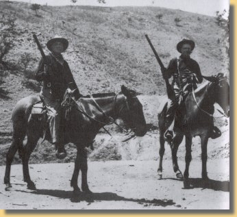 Zwei gut bewaffnete Mulireiter in Arizona ca. 1890